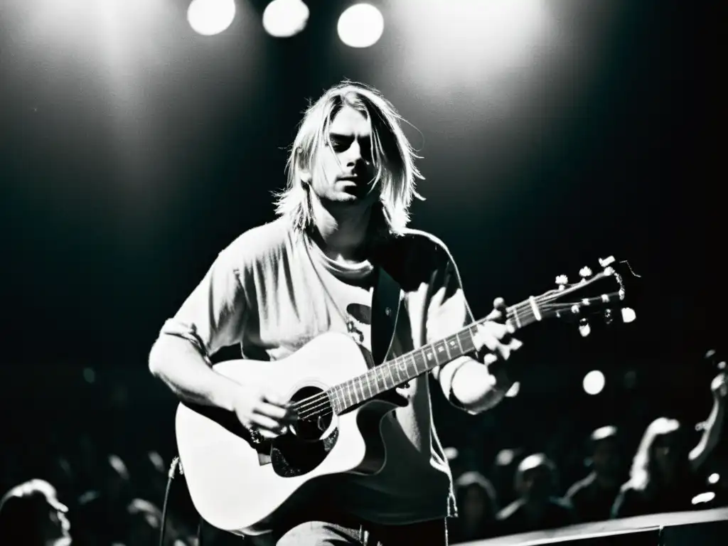 Kurt Cobain tocando la guitarra en un escenario oscuro, destaca su intensa expresión